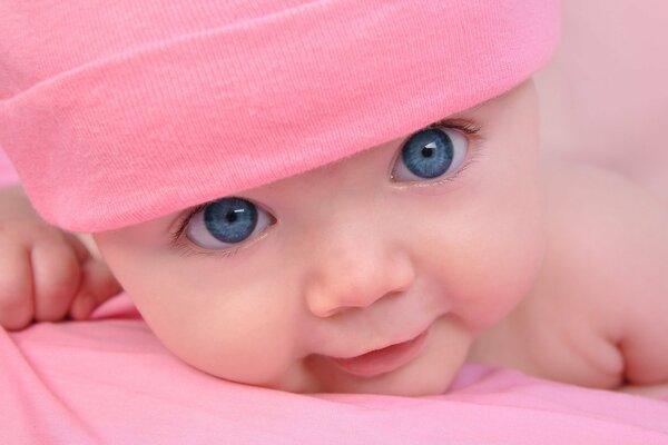 Hermosa chica con ojos azules en un gorro rosa