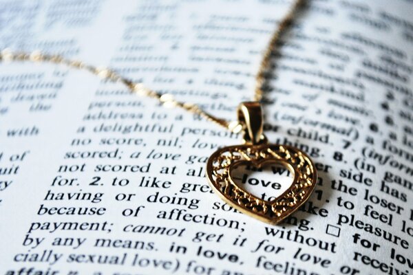 Gold heart pendant on an open book