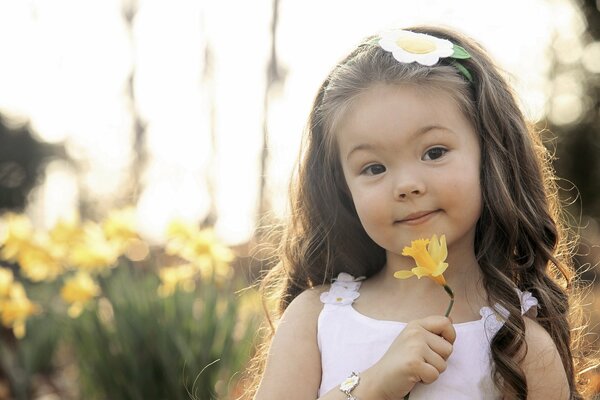 Petite fille avec jonquille jaune à la main