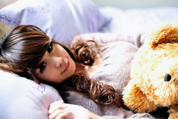 Fille avec un ours en peluche. Pyjama