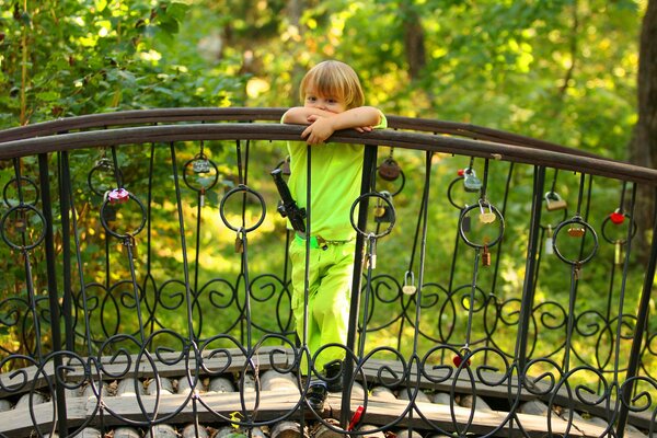 A thoughtful boy stands on the bridge