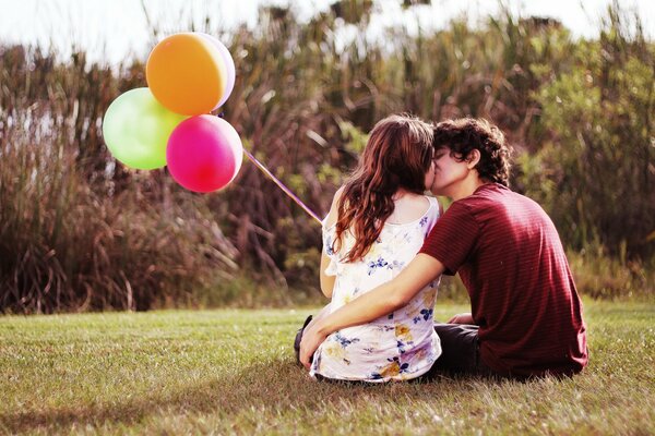 Young kissing couple with balloons