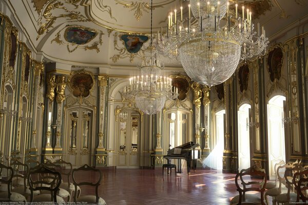 Sala de Palacio con columnas , candelabros, piano de cola