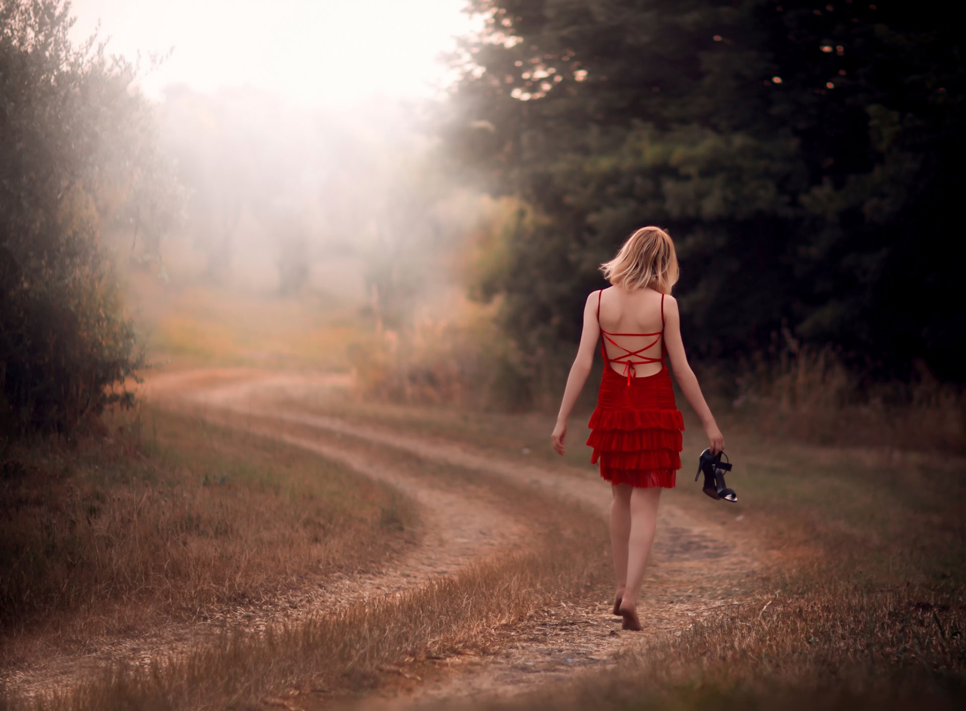 ragazza a piedi nudi in rosso strada campo modo