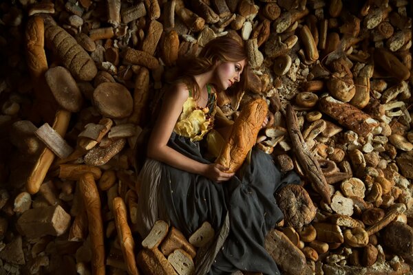 The model girl lies in a variety of loaves of bread