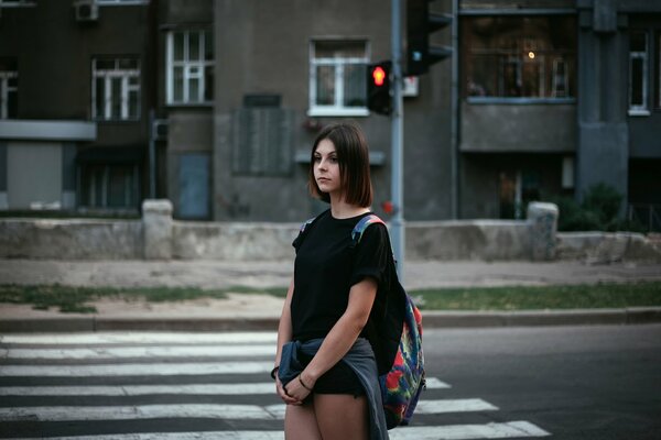 Ragazza solitaria in città al semaforo