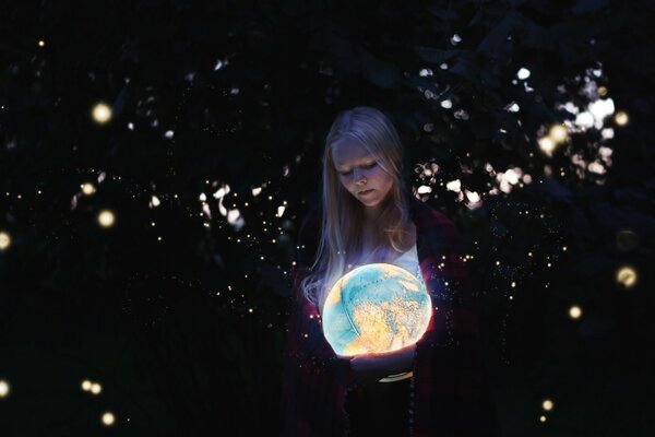 Ragazza bionda con un luminoso globi in mano