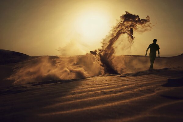 The silhouette of a dragon made of sand and a man