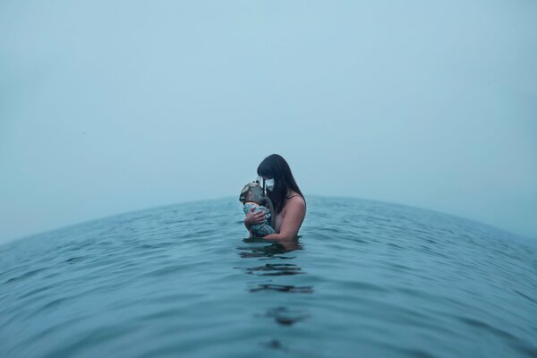 Mädchen im Wasser mit Baby baden