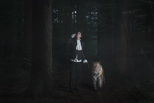 Un hombre con un tigre caminando en el bosque