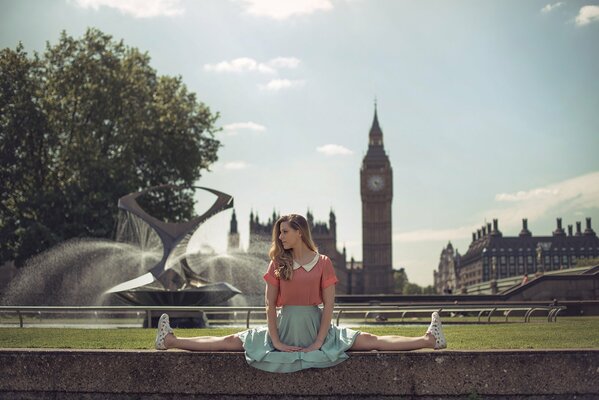 Una chica sentada en un cordel contra el telón de fondo de las vistas de Londres