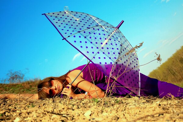 Girl under an umbrella in the field