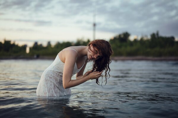 Fille avec des taches de rousseur et les cheveux mouillés dans l eau