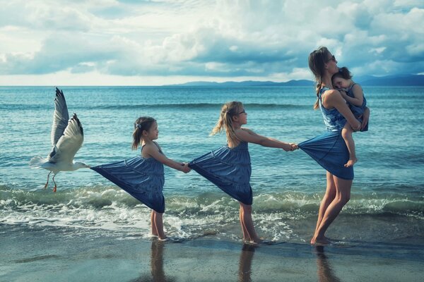 Maman avec les filles sur la côte