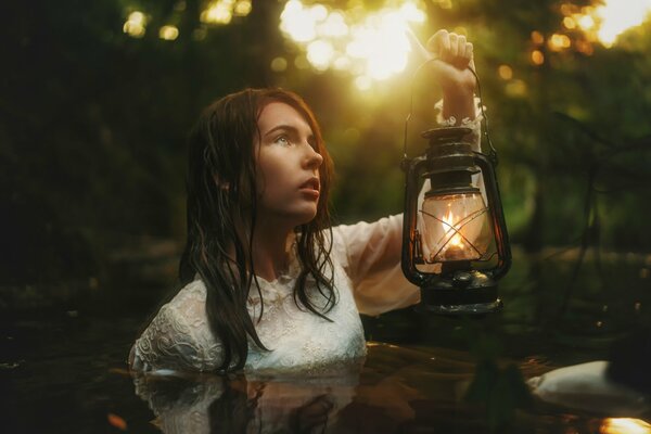 Girl in the water with a night light in the lake