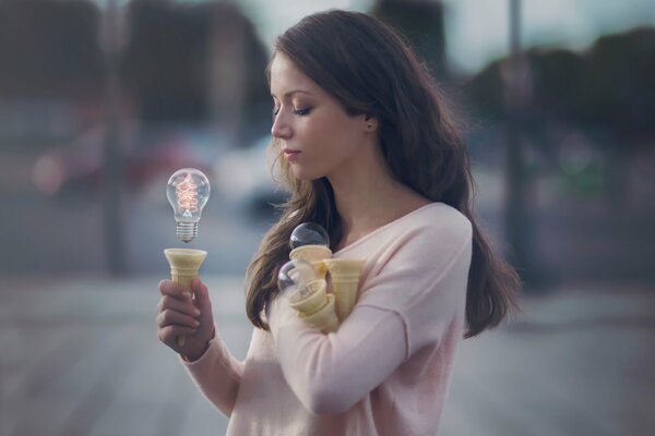 Belle fille de retenue de l ampoule force de la pensée