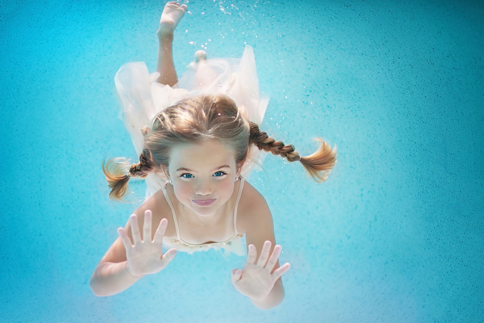 feliz verano niña bajo el agua coletas natación