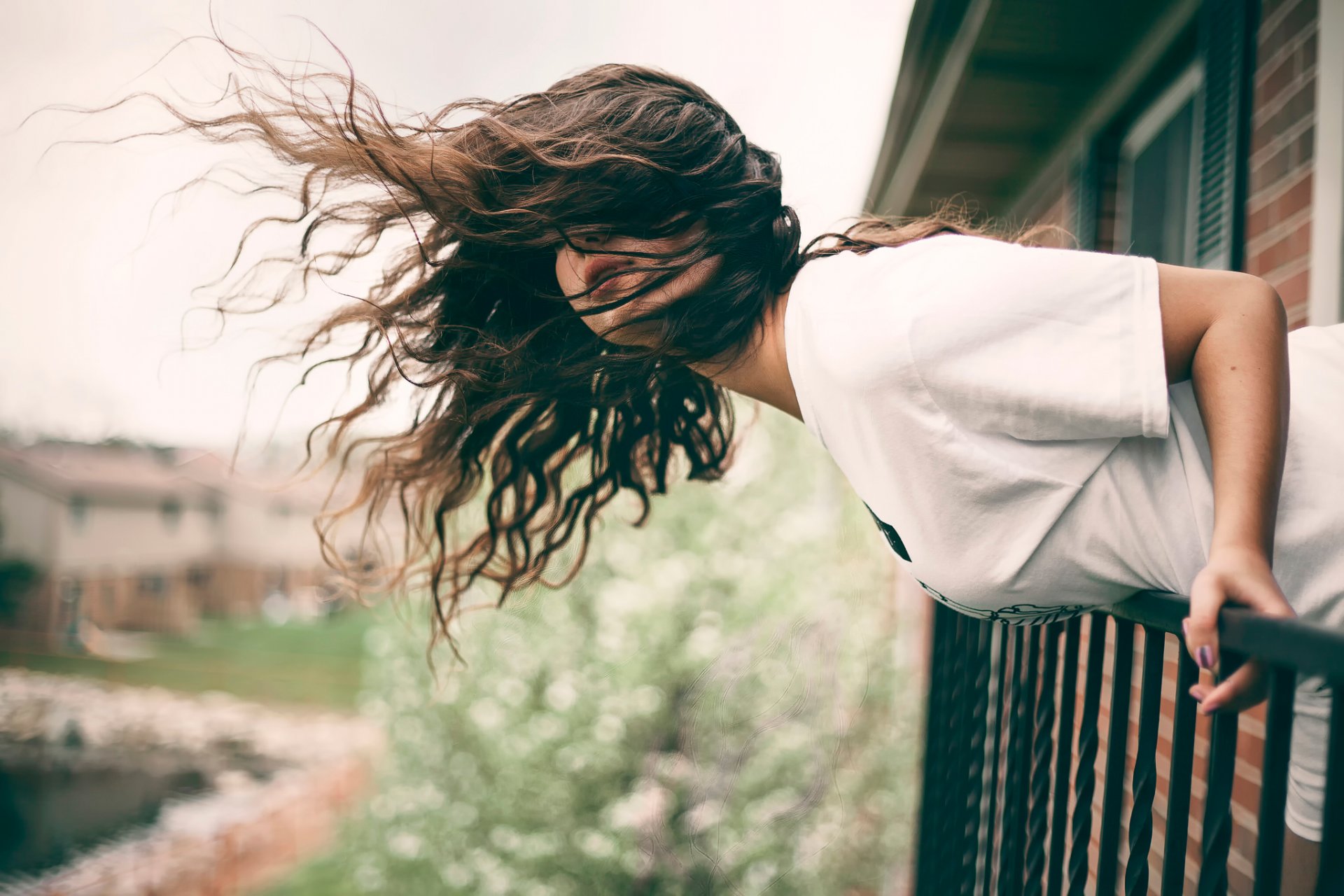 chica balcón pelo viento inclinación