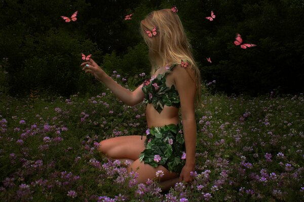 La jeune fille dans une clairière dans les fleurs et les papillons