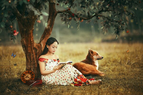 Asiatische Frau mit einem Fuchs in der Nähe eines Baumes