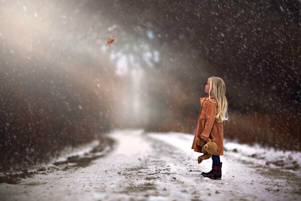 Bosque de invierno. Chica con un oso