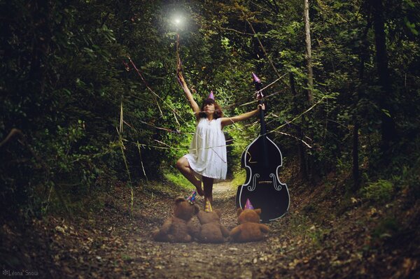 A girl with a double bass in the forest