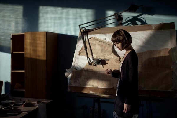 A beautiful girl is standing at the blackboard in the office