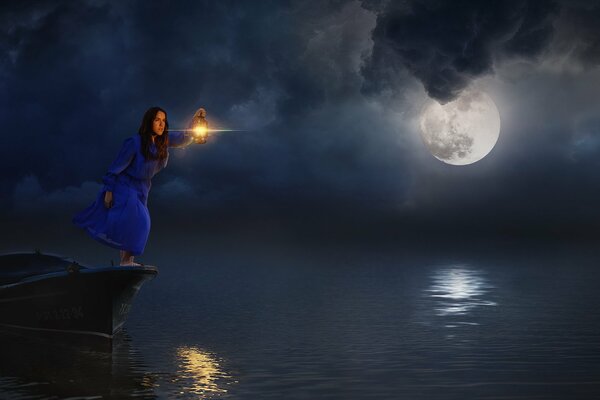 The girl stands on the pier at night with a lamp and looks out the boat