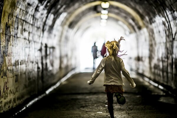 La petite fille traverse un tunnel pour les parents