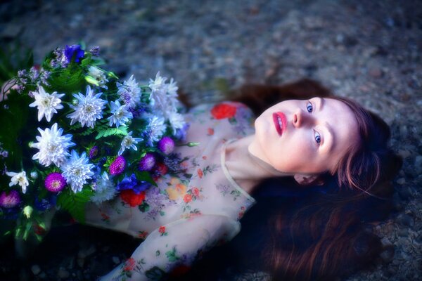 A beautiful girl lies in the water with flowers