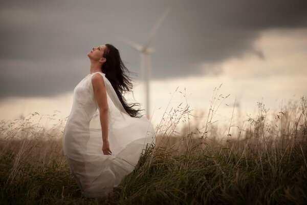 Fille en robe blanche sur fond de moulin à vent