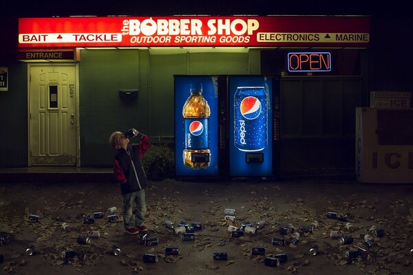 A dark street with Pepsi vending machines