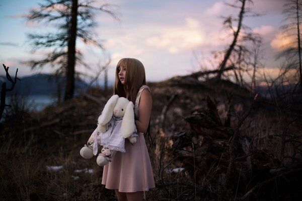 Fille dans la forêt tient un jouet зайченка