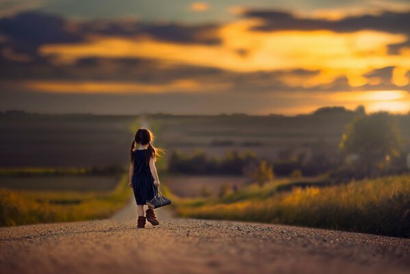 Una niña con un libro en una cuerda camina por el camino