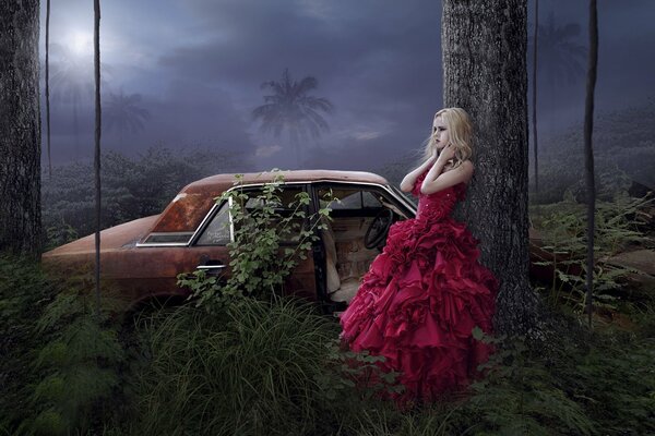 Misteriosa chica con un vestido rojo en la selva