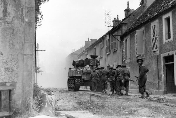 Les soldats vont au-delà de tank parmi les ruines