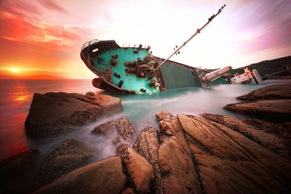 Barco tras naufragio arrojado del mar a las rocas