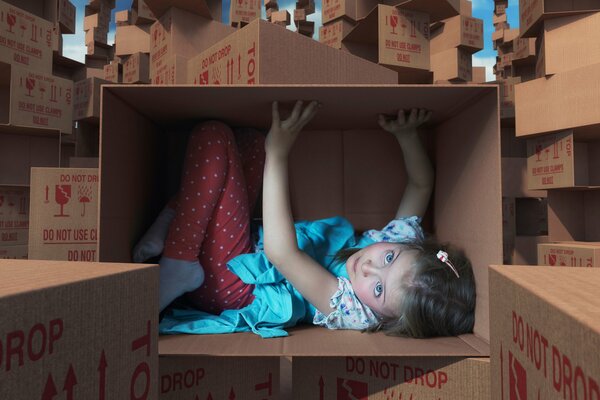 A little girl in a cardboard box