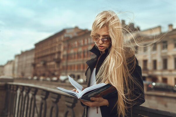 Fille lisant un livre dans la rue