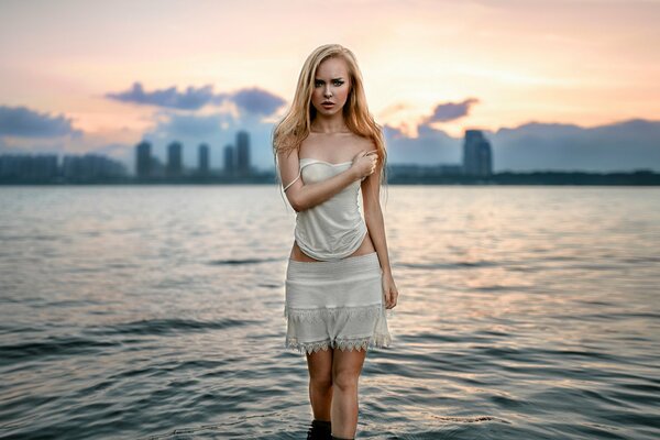 Hermosa chica en el agua en el fondo de la ciudad