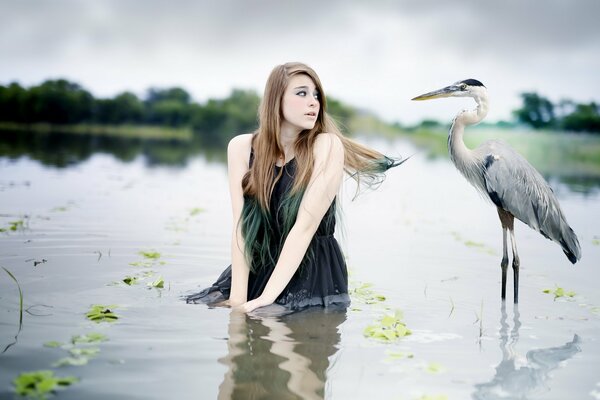 La ragazza nell acqua guarda il grande uccello