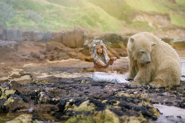 Ein Mädchen und ein Eisbär sitzen auf Steinen