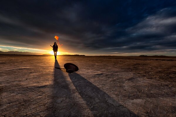 Chica con una cometa en el desierto