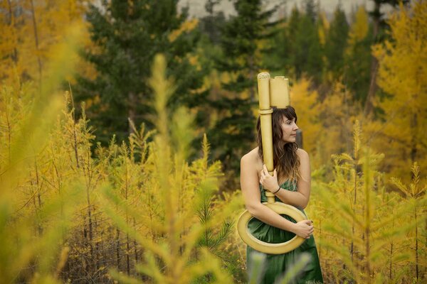 A girl with a key on the background of an autumn forest