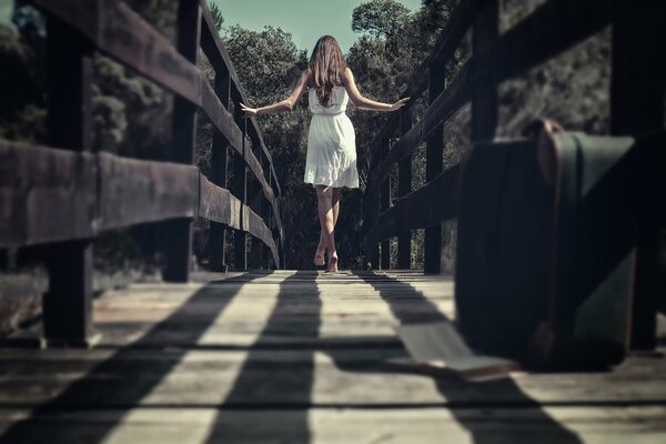 Passeggiata sul ponte. Ragazza in abito bianco