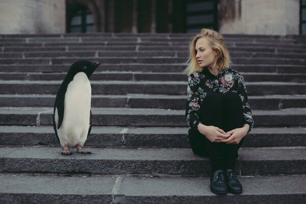 Girl with penguins sitting on the steps