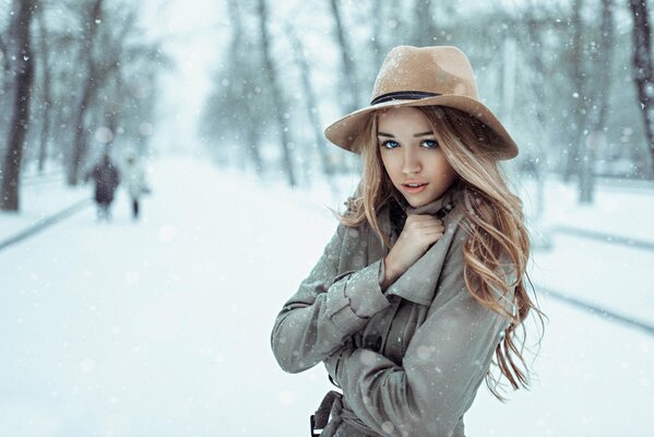 Strada innevata in Russia, in primo piano ragazza in cappotto e cappello