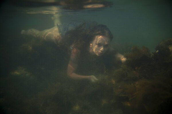 Mädchen auf dem Meeresboden. Fotoshooting unter Wasser