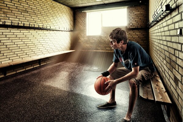 A young man is sitting in the locker room before the game