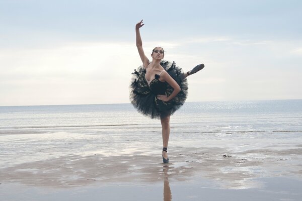 Une fille de ballerine de danse sur la mer